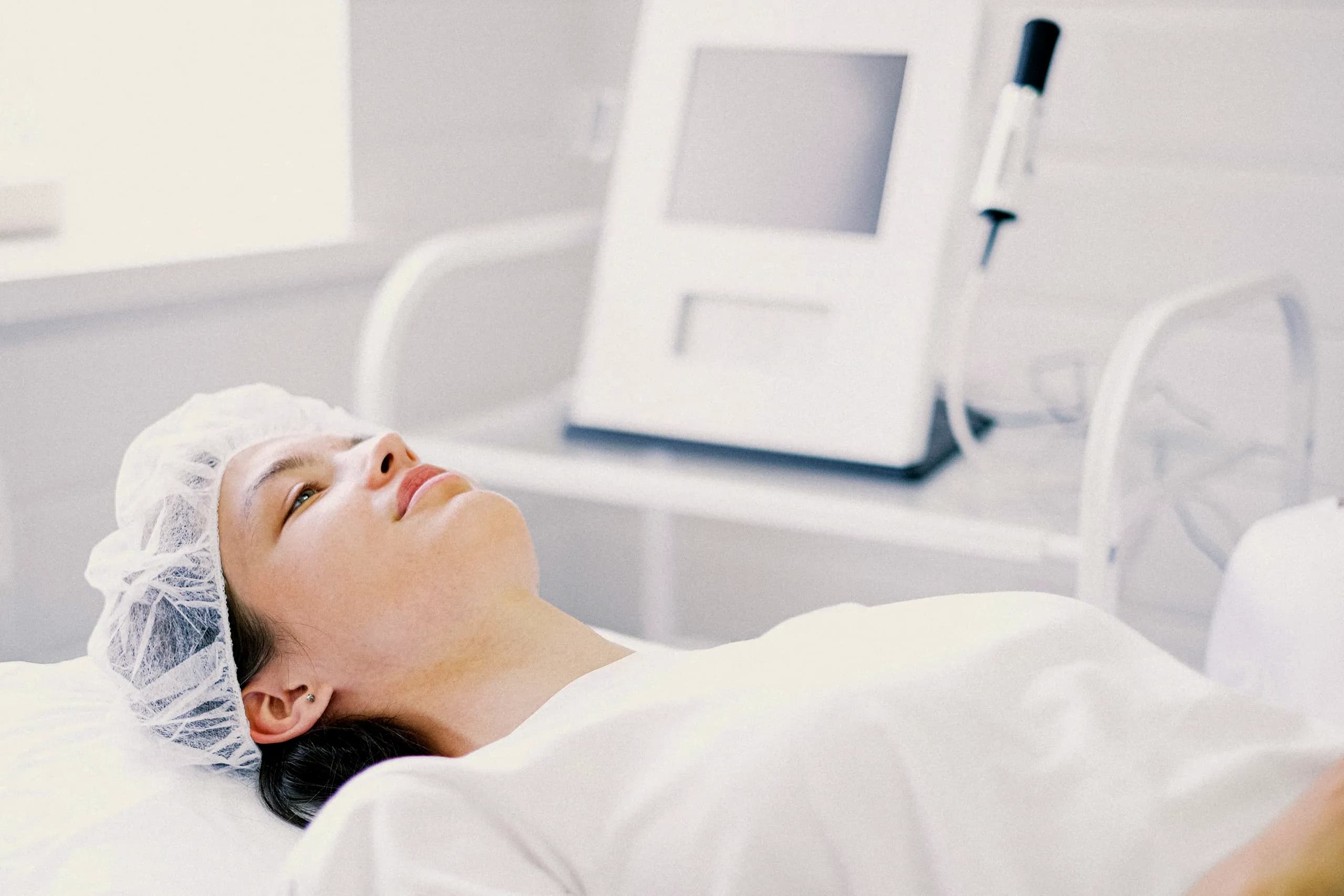 A patient resting comfortably in a bright aesthetics treatment room.