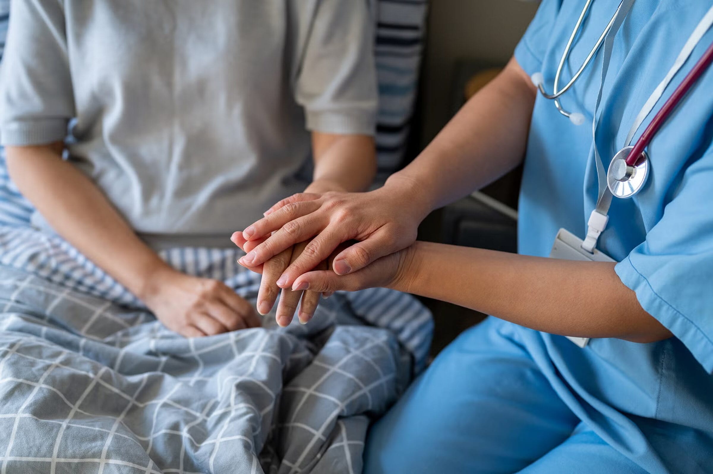 A clinician gently holding a patient's hands